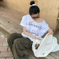 Baggy White Off Shoulder Graphic Top — in alternativa